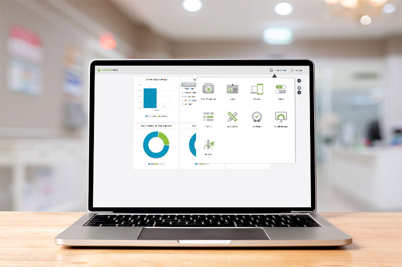 MacBook showing the MDM admin interface on a desk in a hospital