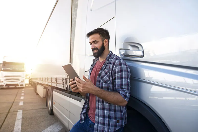 Truck driver with a tablet in the cab