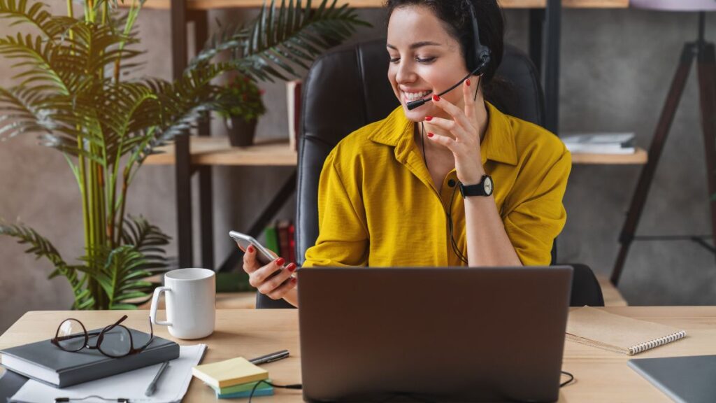 Woman working at home with laptop and smartphone.