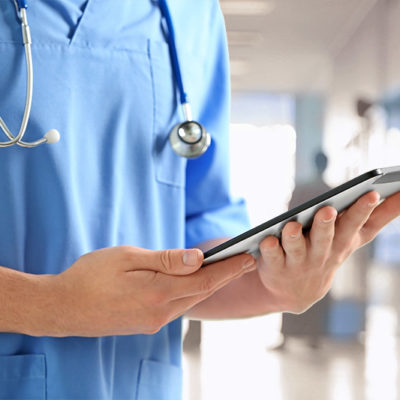 Doctor with tablet in hospital hallway