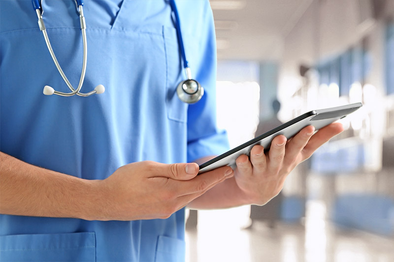 Doctor with tablet in hospital hallway